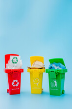 Yellow, Green And Red Recycle Bins With Recycle Symbol On Blue Background. Keep City Tidy, Leaves The Recycling Symbol. Nature Protection Concept