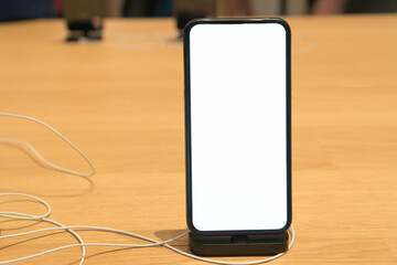 Empty Mockup image white mobile phone with blank background on desk shop in department store, Blank for word or Copy space for text