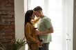 © Ivan - Lovely couple hugging with glasses of wine at home, romantic vibes. Happy young family moved to new apartment