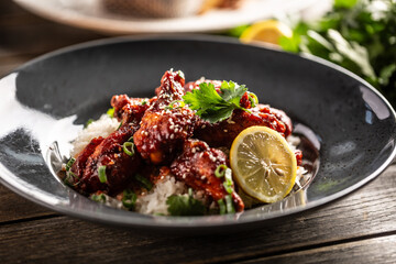 Marinated glazed chicken sprinkled with seesame served over white rice with coriander and a slice of lemon