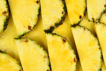 Pineapple juicy yellow slices background. Top view.