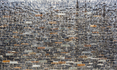 artificial waterfall, water flows along a stone wall