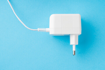 white power supply unit of an electrical appliance, top view on a blue background