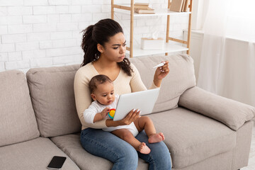 Wall Mural - Mom Caring For Sick Toddler With Fever Using Tablet Indoor