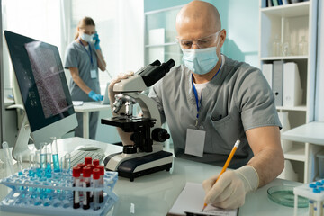 Poster - Lab worker making notes about samples