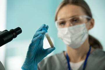 Poster - Laboratory worker holding test tube of muddy liquid