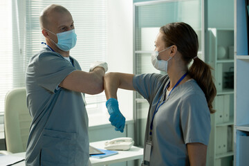 Poster - Surgeons tapping elbows together