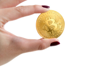 Close up of one golden coin with the Bitcoin symbol on white background. Young woman's hand holding cryptocurrency coin, digital money, BTC