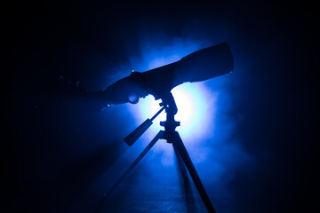 Wall Mural - silhouette of a astronomy telescope on dark foggy backlight.