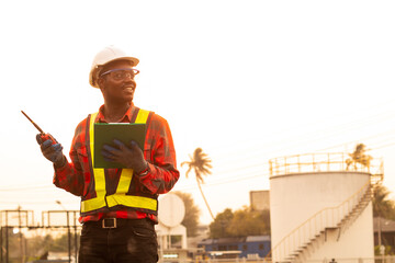 Wall Mural - African man engineer use radio communication working at oil industrial