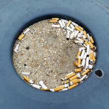 Outdoor Public Ashtray With Spent Cigarette Butts.
