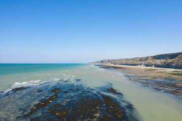 Canvas Print - La plage et les falaises du port en Bessin en France, en Normandie, dans le Calvados, au bord de la Manche.