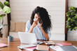 © InsideCreativeHouse - Sick ill young businesswoman asking for sick leave on the phone in office. Sick african american girl working from home office.