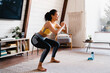 © InsideCreativeHouse - Sporty young african woman exercising at home. Healthy and sporty lifestyle. Attractive young African American slim sporty girl does sports on fitness mat, does sit-ups with her arms outstretched