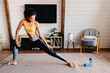 © InsideCreativeHouse - Young african-american fit girl stretching at home in fitness outfit. An african-american athletic woman is doing workout at home. Healthy lifestyle concept