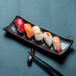 Vertical shot of fresh tuna, salmon, scallop, nigiri, and shrimp sushi and chopsticks