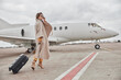 © Yaroslav Astakhov - Mature business woman in coat near her jet in airport