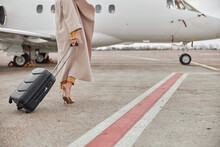 Mature Business Woman In Coat Near Her Jet In Airport