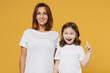 Happy woman in basic white tshirt have fun with child baby girl 5-6 years old raised finger up idea Mom little kid daughter isolated on yellow color background studio Mother's Day love family concept