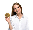 Bitcoin coin in the hand of a smiling young woman. Mining and cryptocurrency concept