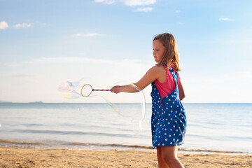 Kids blow bubble at beach. Child with bubbles