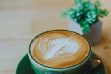 cups of latte coffee with latte art on wooden background. Beautiful foam, greenery ceramic cups