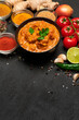 Plate of Traditional Chicken Curry and spices on dark concrete background
