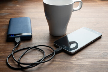 a mobile phone connected to a power bank for charging