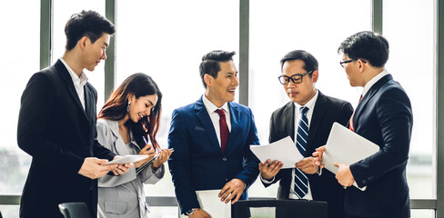 Wall Mural - Group of professional asian business meeting and discussing with new startup idea project.Creative business people planning strategy analysis and brainstorm with document report in office.Teamwork