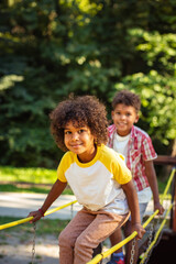 Wall Mural - Brother and sister playing in nature. Focus is on little girl.