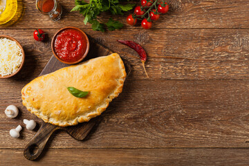 Wall Mural - Italian calzone with mushrooms and ham. Top view.