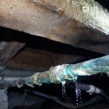 Water Leak In Corroded Copper Water Pipe In The Plumbing Under A Traditional Villa In New Zealand.