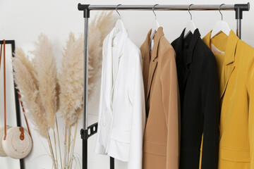 corner in fashion atelier with fashionable tailored blazers hanging on a rack. modern premium qualit
