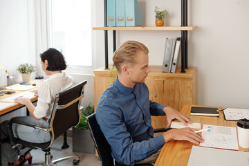 Wall Mural - Business people working with charts and repots at tables in small office