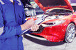 © Creativa Images - Male mechanic writing report of car maintenance