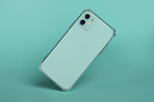 Green Smartphone In Clear Silicone Case Falls Down, Back View Isolated On Green Background, Phone Case Mockup