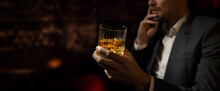Man Wearing Suit Sits In The Luxury Bar In Gentlemen Club And Drink Whiskey. Copy Space