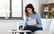 © Syda Productions - accounting, taxes and finances concept - young woman with papers and calculator at home