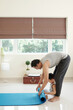 © DragonImages - Little boy helping father to roll up yoga mat after training together at home