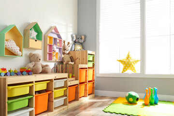 Poster - Stylish playroom interior with shelving unit and different soft toys