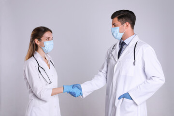 Wall Mural - Doctors shaking hands on light grey background