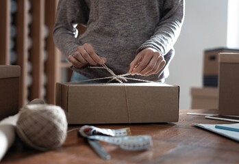  Indian mixed-race female business owner working, packing the order for shipping to customer