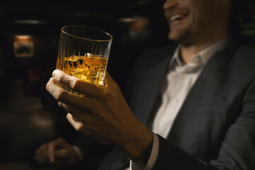 happy businessman with glass of whiskey in gentlemen club bar