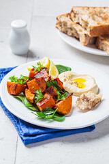 Poster - Baked sweet potato slices with spinach and hummus on white plate.