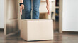 © Prostock-studio - Unrecognizable person picking cardboard box up from the floor