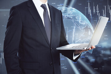 Poster - Businessman in a suit holding a laptop with a hologram globe in the background. International and worldwide communication concept