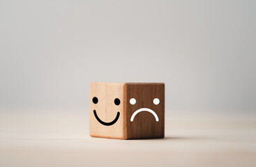 Wall Mural - Smiley face on bright side and sadness on dark side of wooden cube block , Emotion selection and mindset concept.