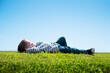 © Ivan Kmit - Happy little boy laying on green grass