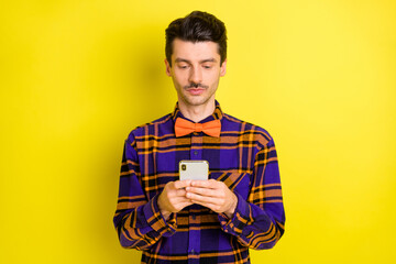 Sticker - Photo of young serious man look browse internet cellphone chat type sms isolated over yellow color background