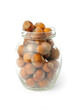 Glass jar with nuts on white background